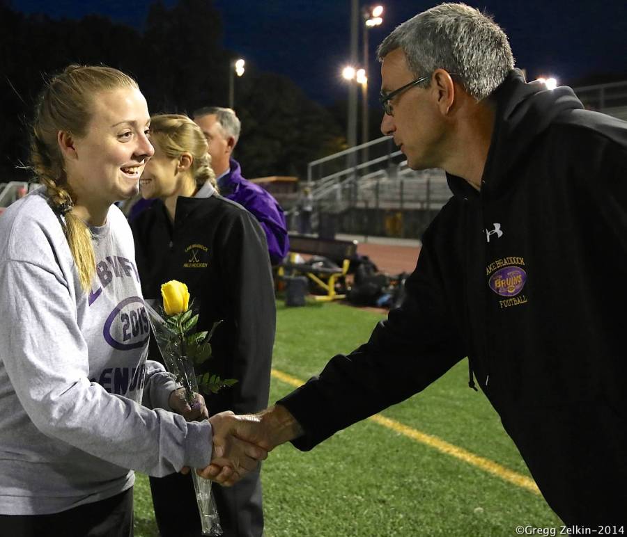 Athletic Director Mark Martino shakes the hand of senior Olivia Olsen on Senior Night for field hockey.